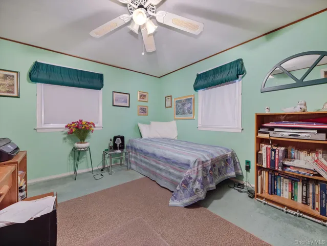 a bed room with a bed and a ceiling fan