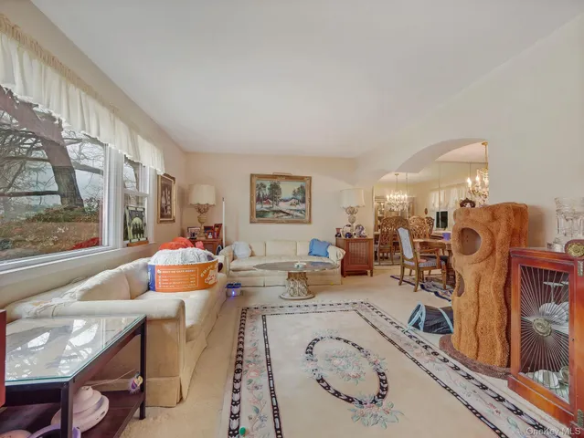 a living room with furniture a flat screen tv and a window