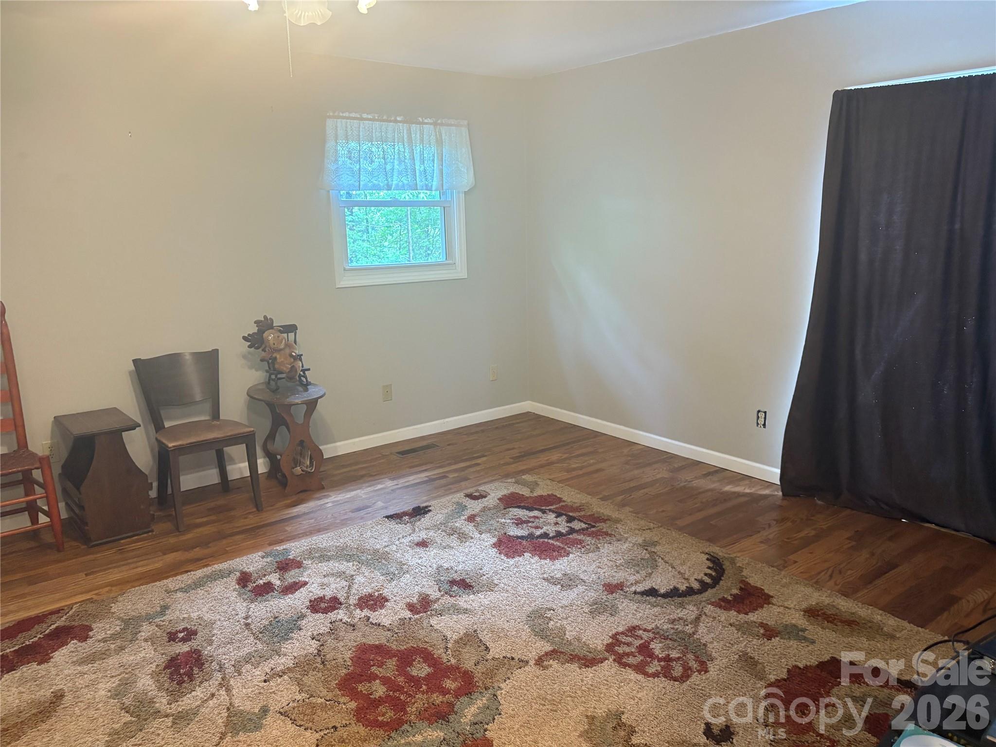 3880 Love Road Claremont, NC 28610 - Photo 8 of 14 a view of a bedroom with wooden floor and lounge chair