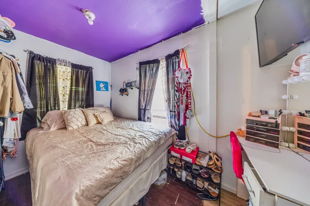 a bedroom with a bed and a flat screen tv