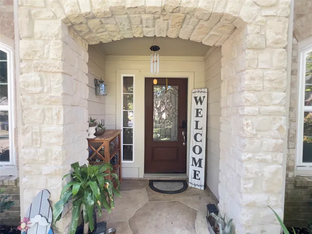 a view of a entryway door with potted plants