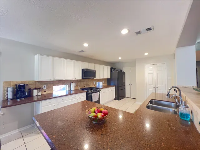 a kitchen with stainless steel appliances a sink a stove a microwave a sink and cabinets