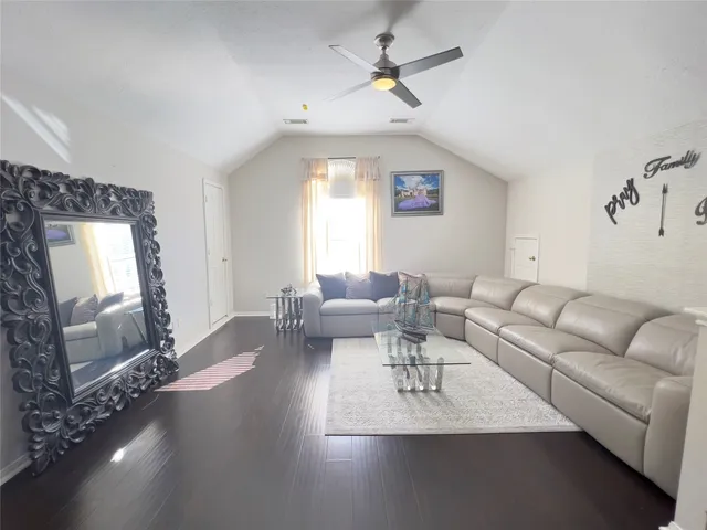 a living room with furniture and wooden floor