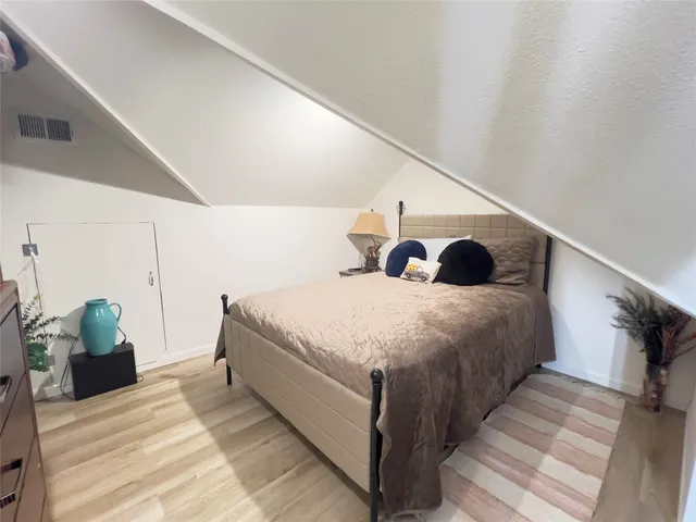 a bed sitting in a bedroom next to a lamp