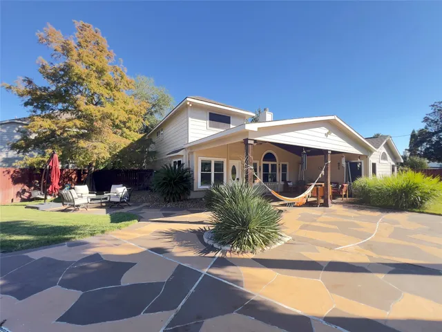 a view of a patio with a dining table and chairs with wooden floor