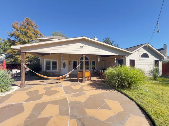 a view of a white house with a big yard and palm trees
