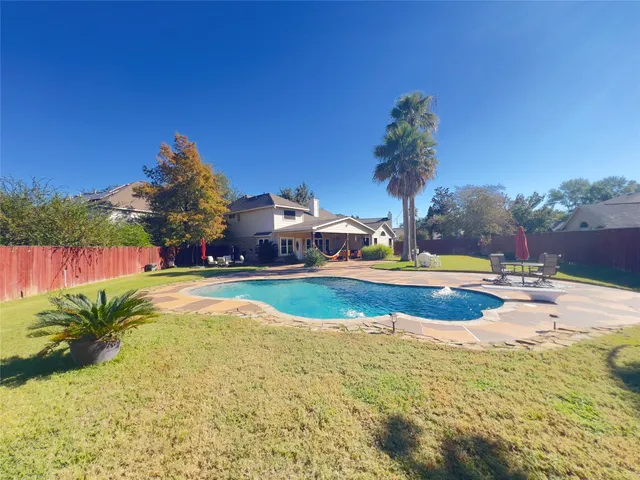 a view of a swimming pool and trees in the background