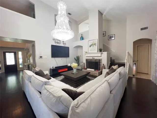 a living room with furniture a fireplace and a chandelier