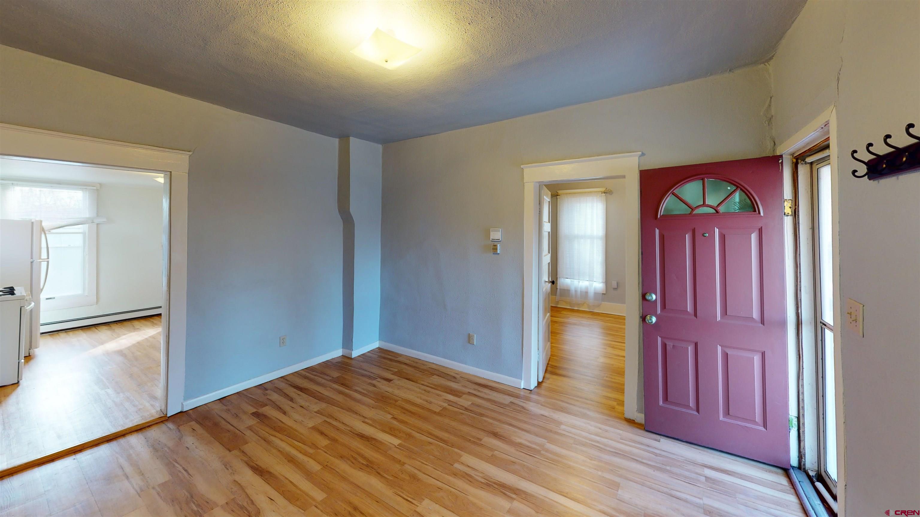 1016 Lincoln Avenue Alamosa, CO 81101 - Photo 4 of 10 a view of a hallway with wooden floor and windows