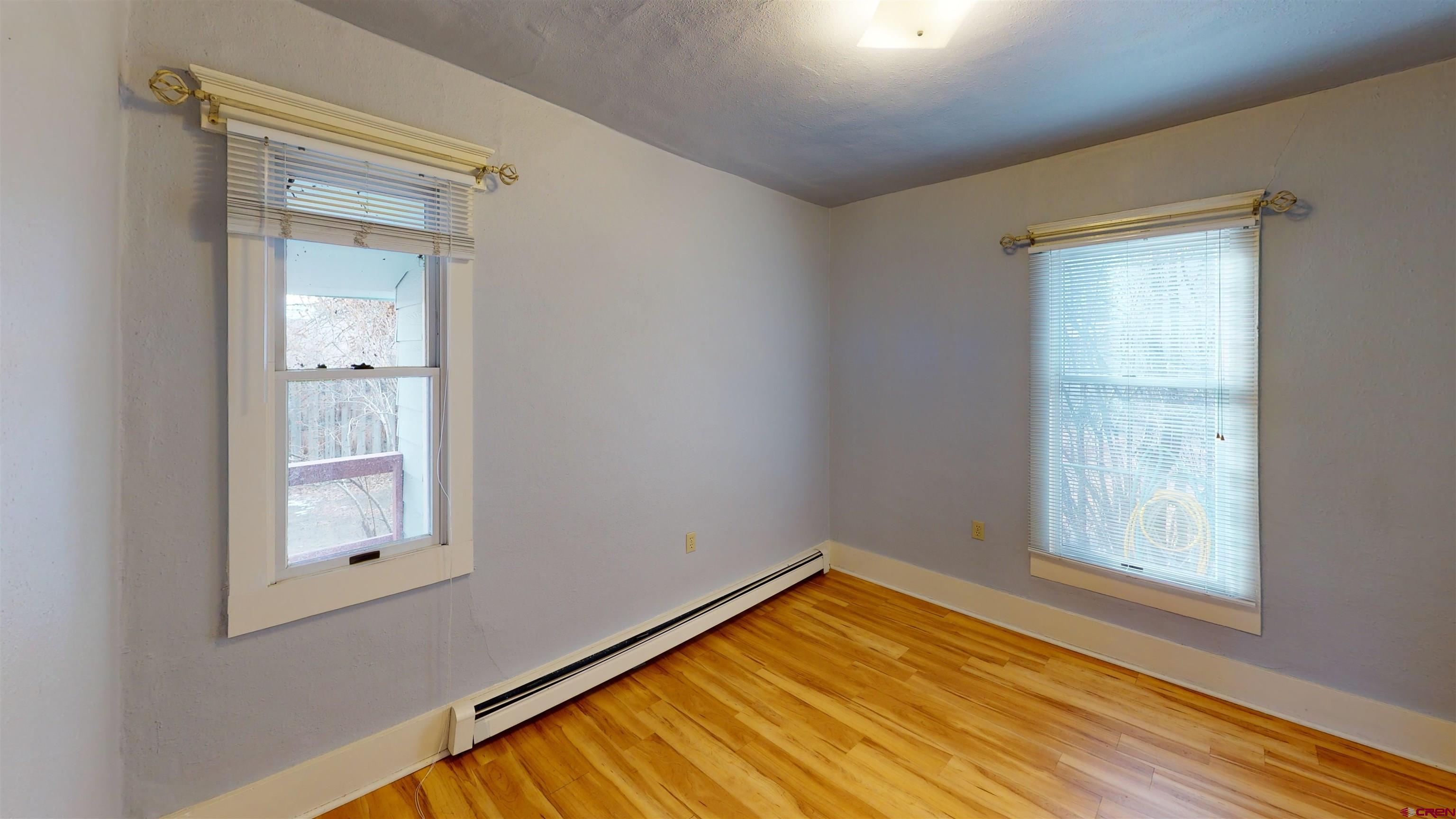 1016 Lincoln Avenue Alamosa, CO 81101 - Photo 8 of 10 a view of an empty room with wooden floor and a window