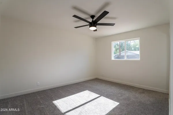 an empty room with windows and fan