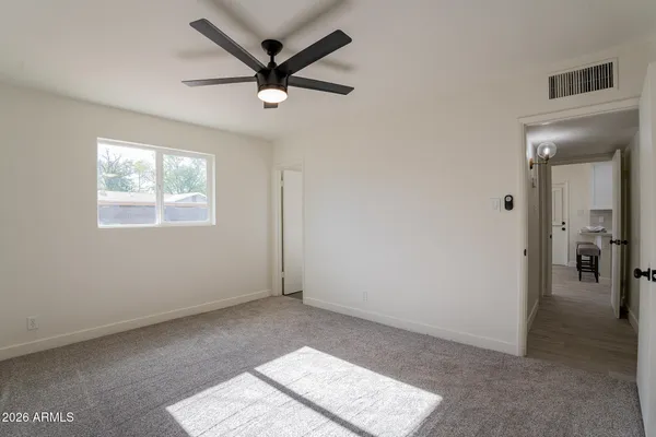 a view of a big room with wooden floor and windows