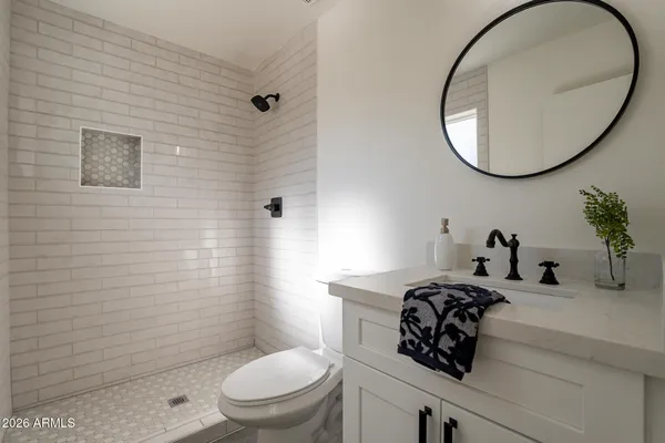 a bathroom with a sink a toilet and a mirror