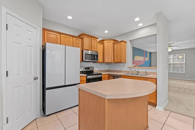 a kitchen with stainless steel appliances a refrigerator a sink a stove top oven a counter space and cabinets