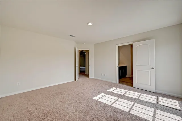 a view of an empty room with window and closet area