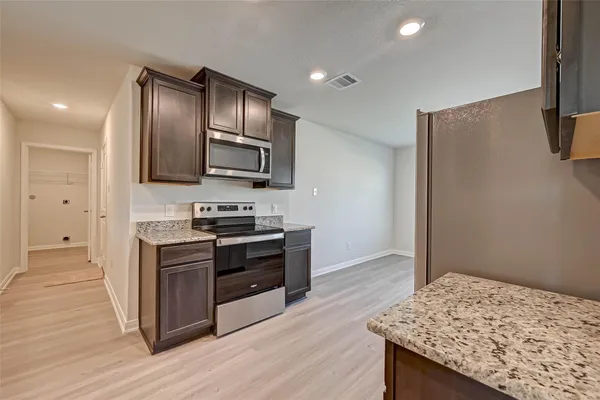 a kitchen with stainless steel appliances granite countertop a stove and a refrigerator