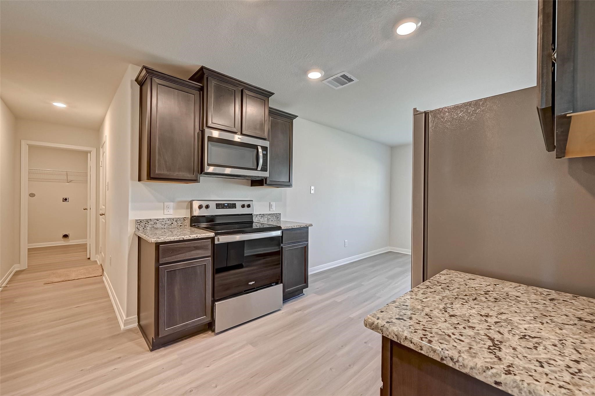 20834 Solstice Point Drive Hockley, TX 77447 - Photo 3 of 16 a kitchen with stainless steel appliances granite countertop a stove and a refrigerator