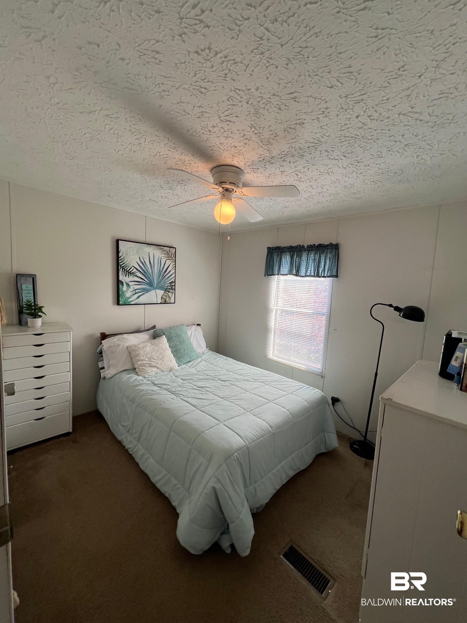 1936 Ridgewood Drive Lillian, AL 36549 - Photo 7 of 30 Carpeted bedroom with visible vents, a ceiling fan, and a textured ceiling