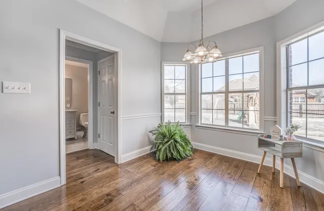 a view of a livingroom with wooden floor and a chandelier