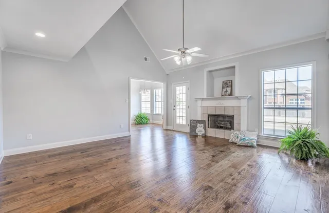 a view of empty room with wooden floor and fireplace