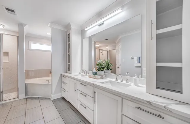 a bathroom with a sink a large mirror and a bathtub