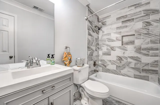 a bathroom with a sink toilet vanity and shower