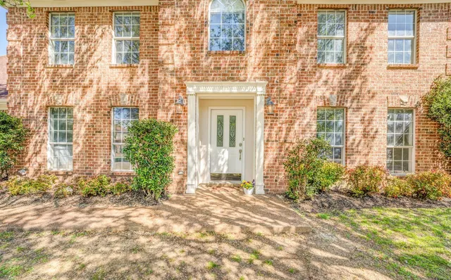 front view of a brick house with a large window