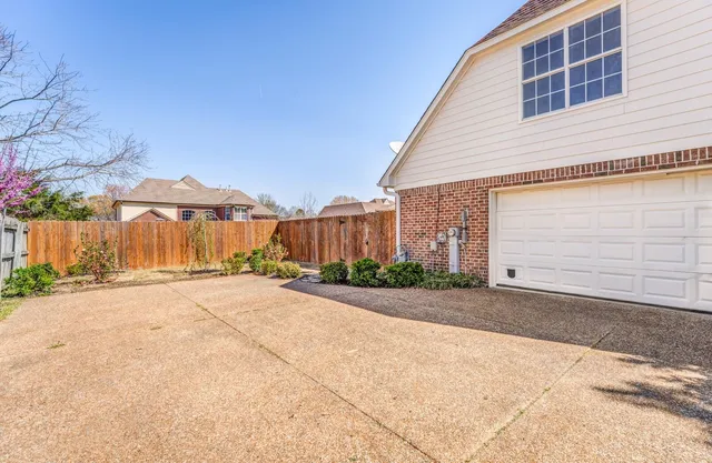 a view of a house with a yard and road