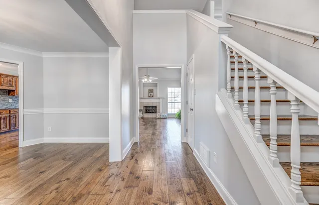 a view of a hallway with wooden floor and staircase