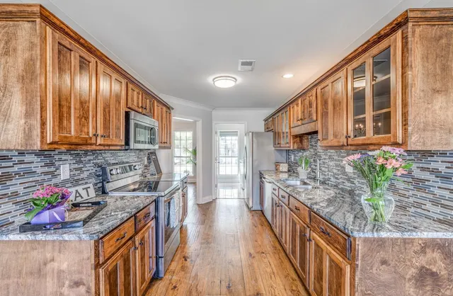 a kitchen with stainless steel appliances granite countertop a stove and cabinets