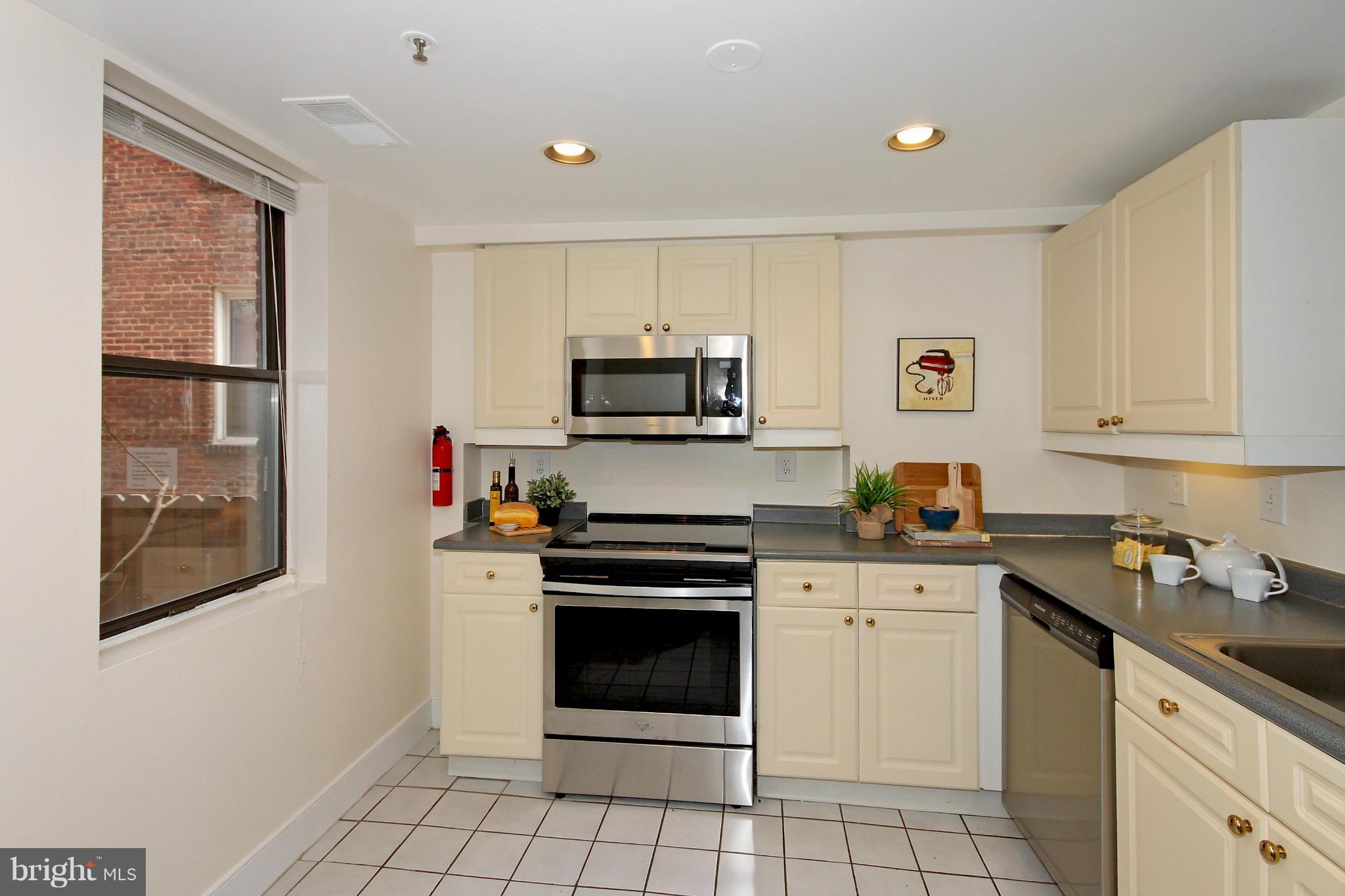 1727 R Street Northwest, Unit 101 Washington, DC 20009 - Photo 7 of 30 a kitchen with granite countertop a stove sink and cabinets