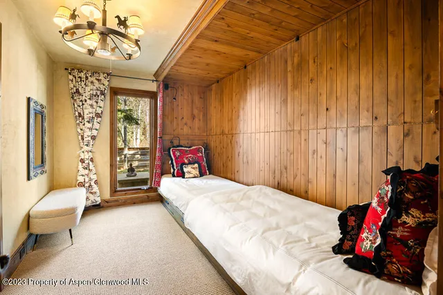 a bedroom with a bed and a chandelier