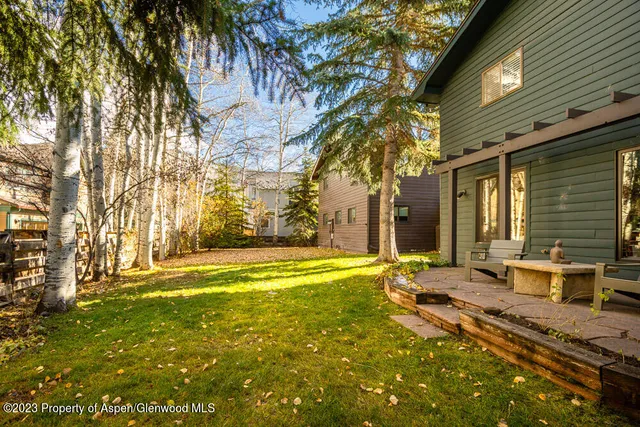 a backyard of a house with table and chairs