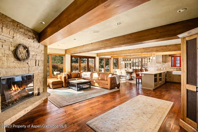 a living room with fireplace furniture and a large window