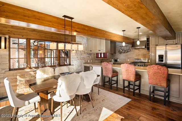 a dining room with stainless steel appliances kitchen island granite countertop a table and chairs