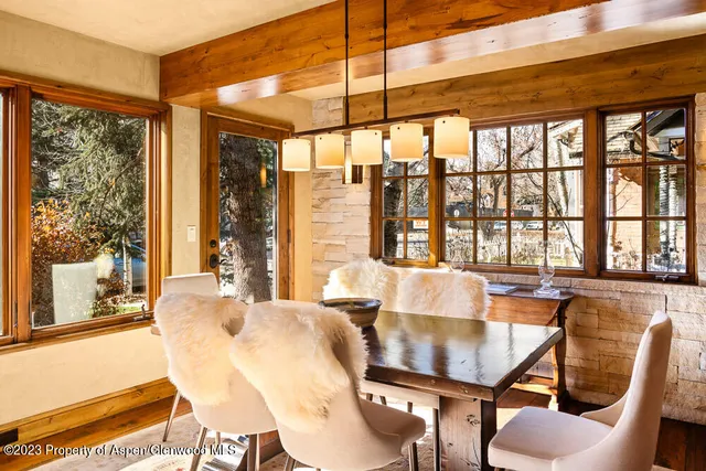 a dining room with furniture and large windows