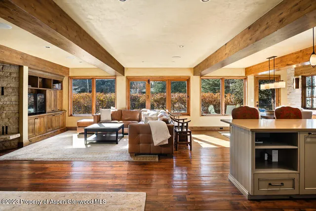 a living room with fireplace furniture and a large window