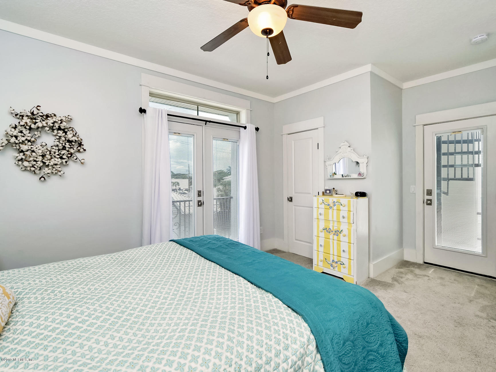 345 Ahern Street Atlantic Beach, FL 32233 - Photo 21 of 44 a bedroom with a bed and a chandelier