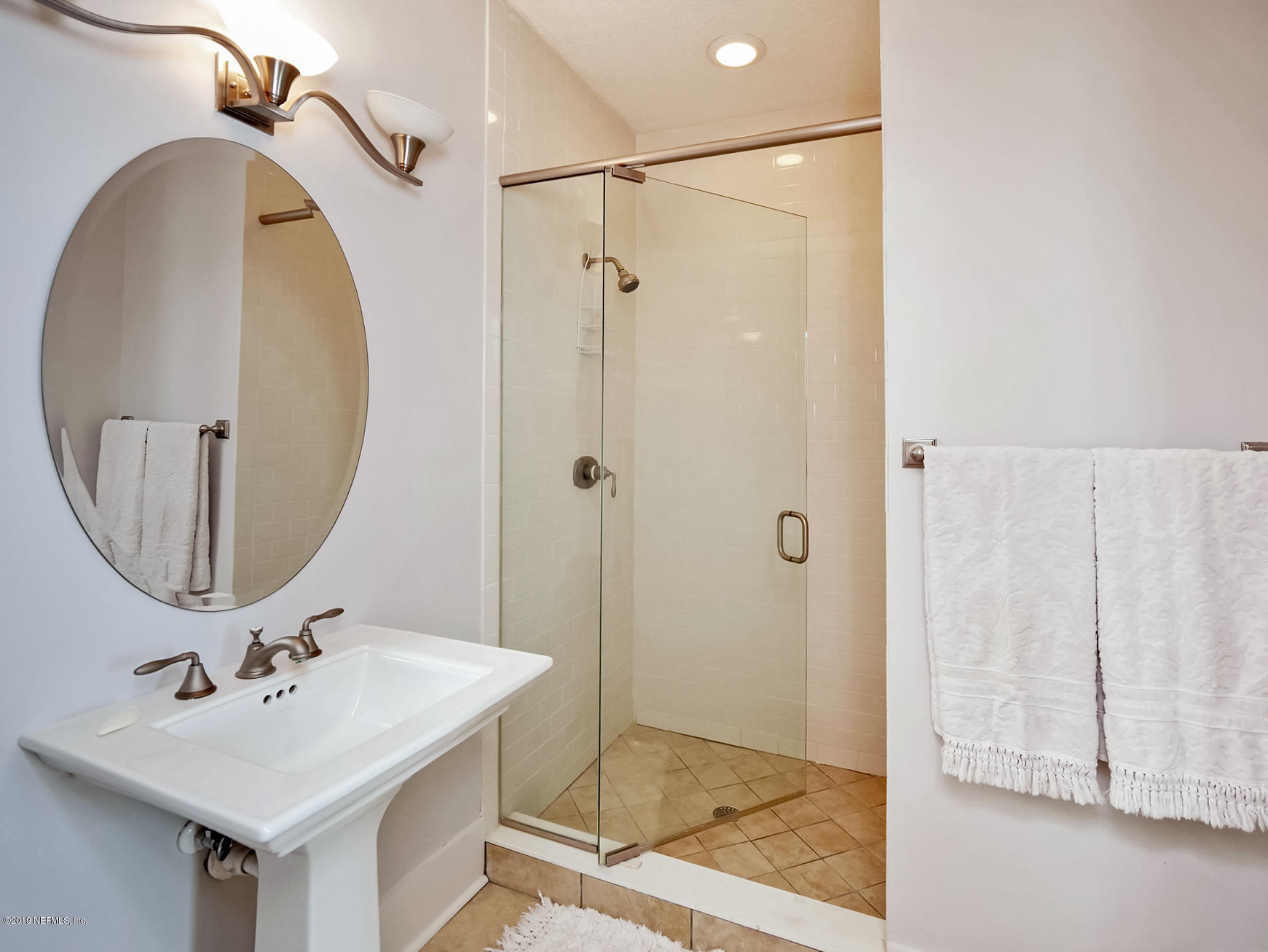 345 Ahern Street Atlantic Beach, FL 32233 - Photo 25 of 44 a bathroom with a sink a glass door a mirror and a shower