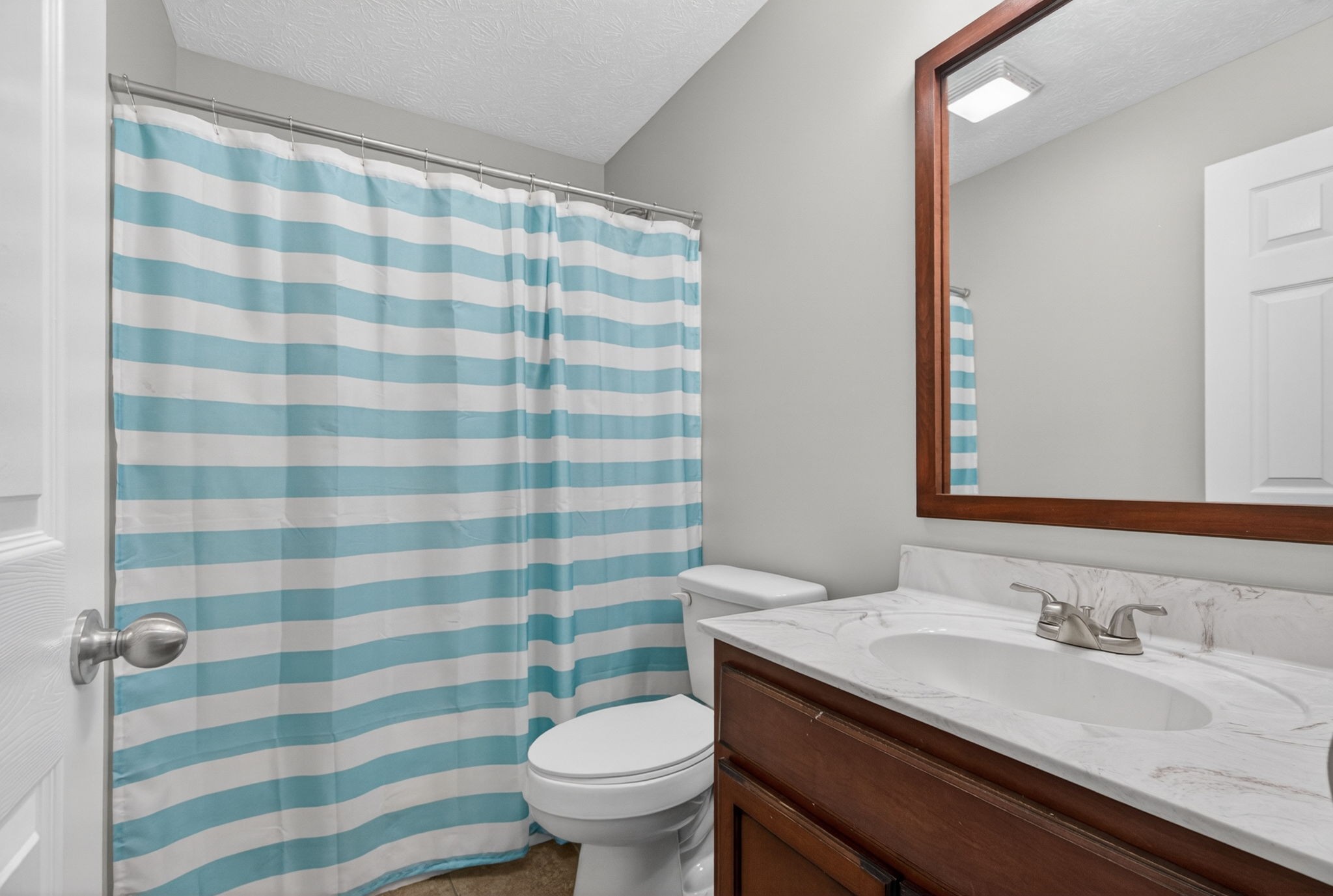 126 Hollands Way Portland, TN 37148 - Photo 25 of 42 a bathroom with a granite countertop toilet a sink a mirror and shower curtain