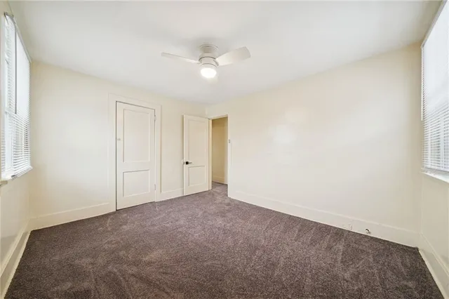 an empty room with a ceiling fan and a window