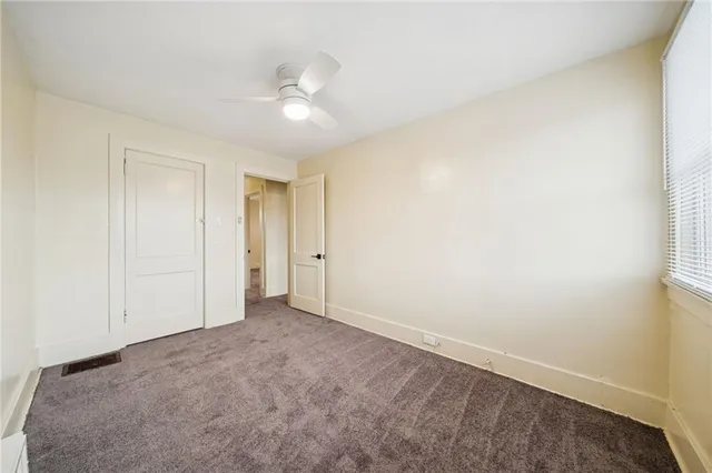 an empty room with a chandelier fan