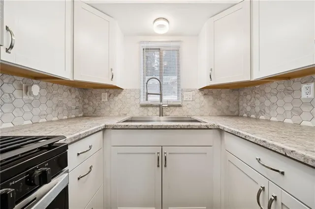 a kitchen with granite countertop cabinets stainless steel appliances and a counter space
