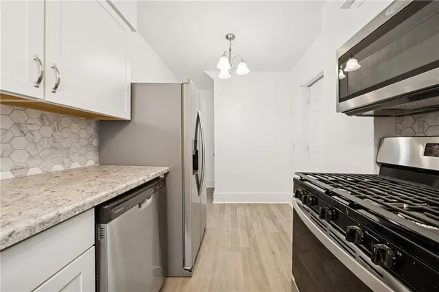 a kitchen with stainless steel appliances granite countertop a stove and a refrigerator