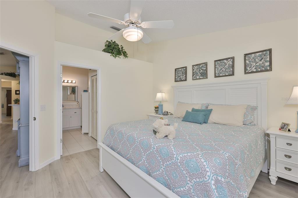 2012 Nantucket Drive, Unit 22 Sun City Center, FL 33573 - Photo 18 of 90 a spacious bedroom with a bed and a chandelier