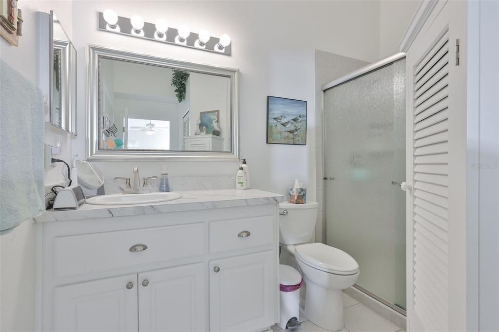 2012 Nantucket Drive, Unit 22 Sun City Center, FL 33573 - Photo 19 of 90 a bathroom with a granite countertop sink mirror vanity and toilet