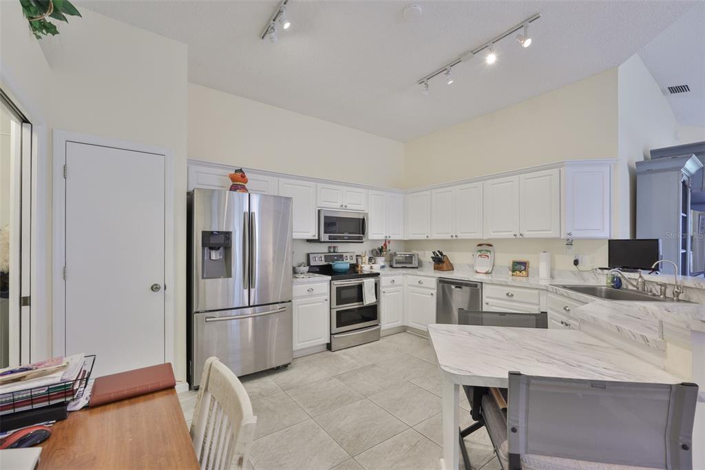 2012 Nantucket Drive, Unit 22 Sun City Center, FL 33573 - Photo 10 of 90 a kitchen with a refrigerator a stove top oven a sink and cabinets