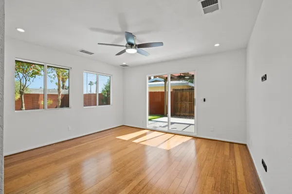 a view of an empty room with a window and wooden floor
