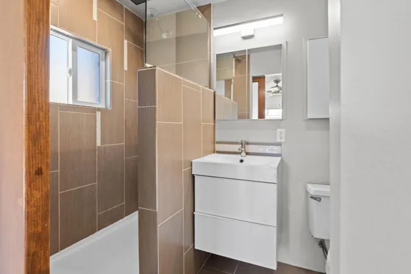 a bathroom with a sink a toilet and shower