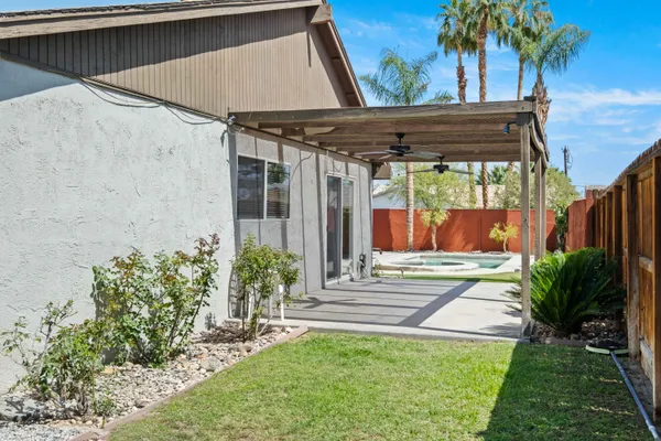 a view of a backyard with plants and wooden fence